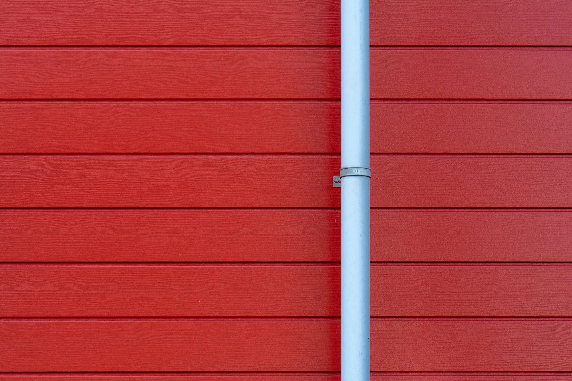 A downspout running down the lap siding of a house